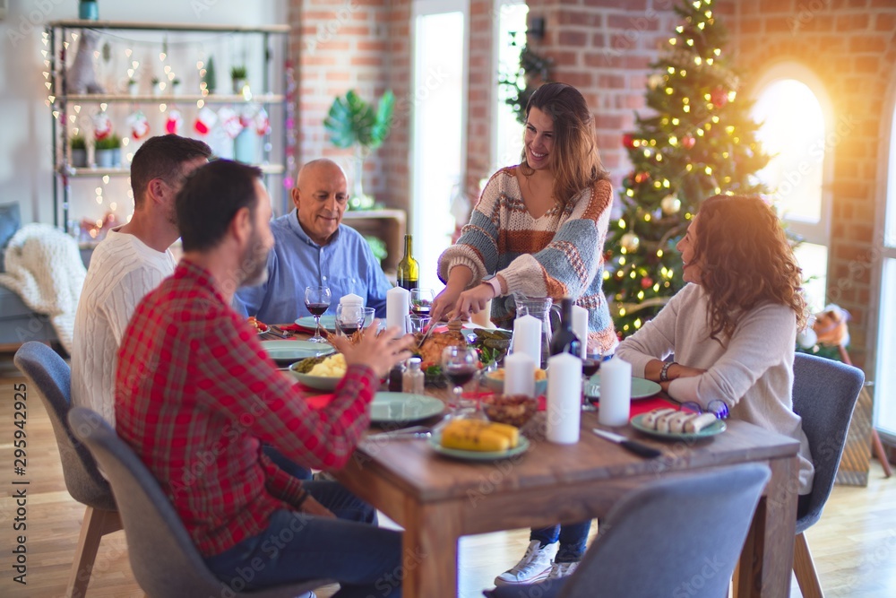Beautiful family smiling happy and confident. Carving roasted turkey celebrating Christmas at home Beautiful family smiling happy and confident. Carving roasted turkey celebrating Christmas at home