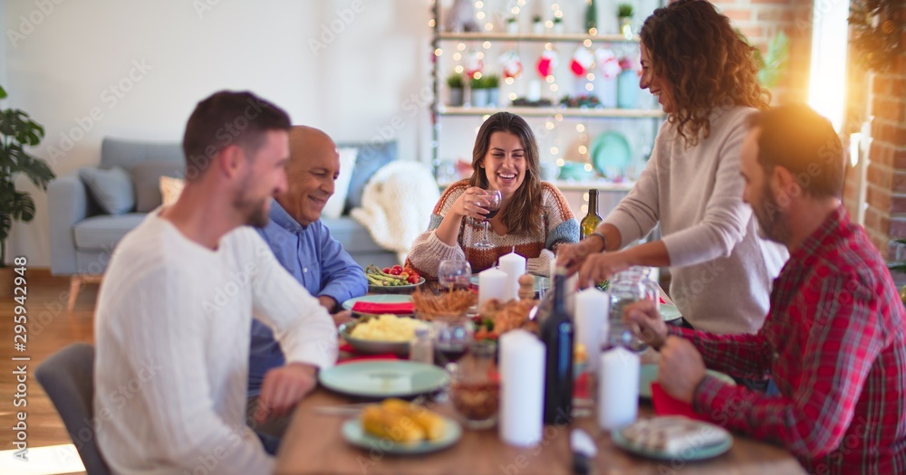 Beautiful family smiling happy and confident. Carving roasted turkey celebrating Christmas at home