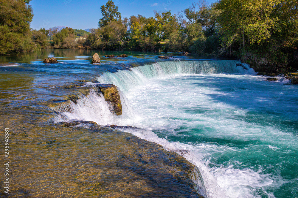 under a bright blue sky you can see the waterfall of Manavgat under a bright blue sky you can see the waterfall of Manavgat