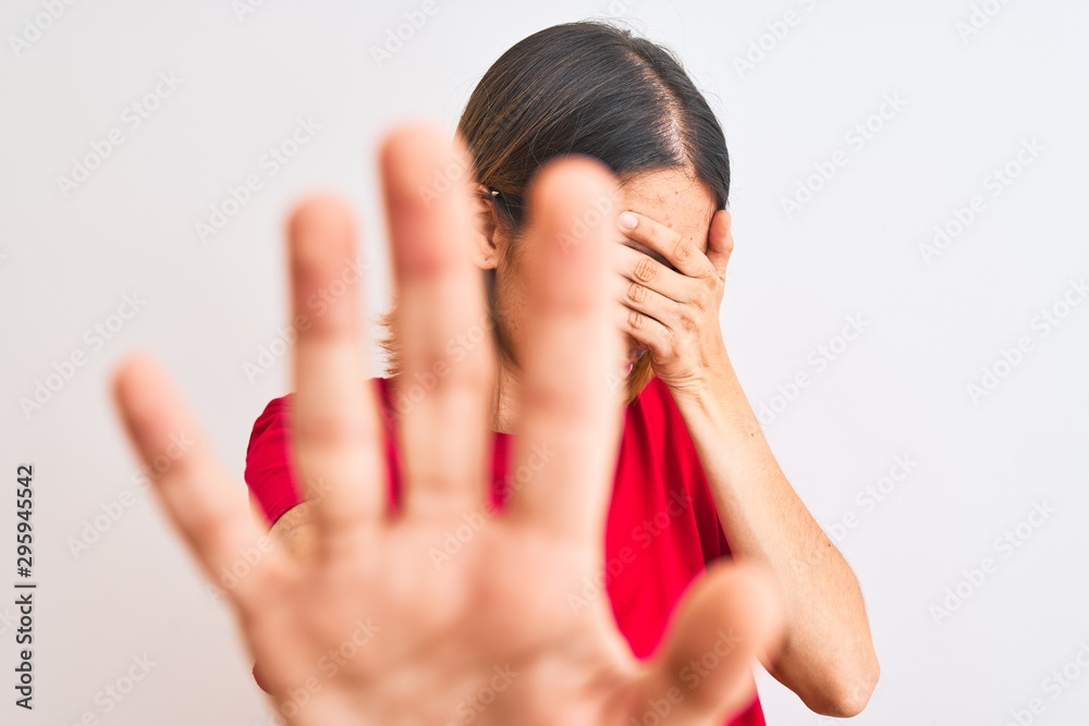 Beautiful redhead woman wearing casual red t-shirt over isolated background covering eyes with hands and doing stop gesture with sad and fear expression. Embarrassed and negative concept. Beautiful redhead woman wearing casual red t-shirt over isolated background covering eyes with hands and doing stop gesture with sad and fear expression. Embarrassed and negative concept.
