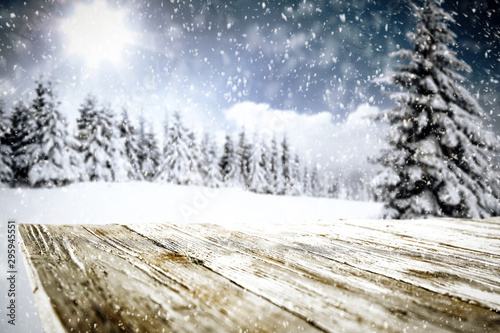 Snowy winter sunshine landscape with wooden board top for products and decorations. © magdal3na