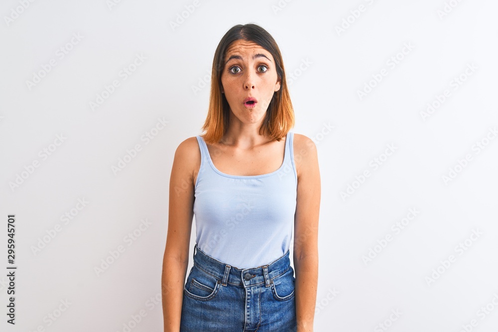 Beautiful redhead woman standing over isolated background afraid and shocked with surprise expression, fear and excited face. Beautiful redhead woman standing over isolated background afraid and shocked with surprise expression, fear and excited face.