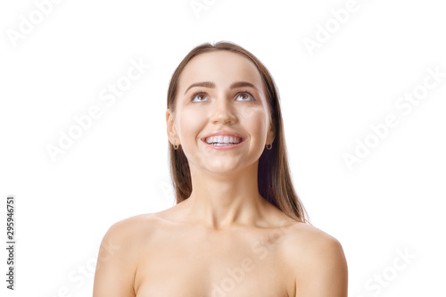 Cute girl with fresh skin and white teeth heads up and looking amased at the top