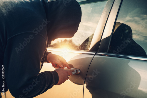 Bild auf Leinwand Car robber or thief trying to break auto door lock, close up