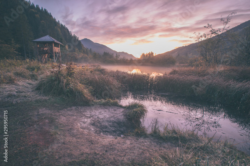 Early morning in the nature reservate of Zelenci, Slovenia, the spring of Sava Dolinka river. Beautiful dreamy morning setting, fairy tale vivid colors and still lake visible. photo