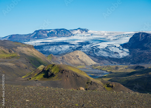 Icelandic landscape with eyjafjallajokull glacier tongue, Markarfljot river and green hills. Fjallabak Nature Reserve, Iceland. Summer blue sky photo