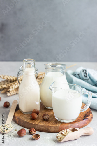 Alternative types of milks in glass bottles. Vegan nondairy milk. Assortment of organic vegan nondairy milk from nuts, oatmeal, seeds.
