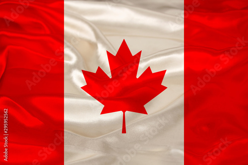 photo of the beautiful colored national flag of the modern state of Canada on textured fabric, concept of tourism, emigration, economics and politics, closeup