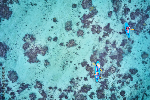 Fototapeta Naklejka Na Ścianę i Meble -  Kayaking on pristine blue water in Fiji from a 5 star resort drone aerial