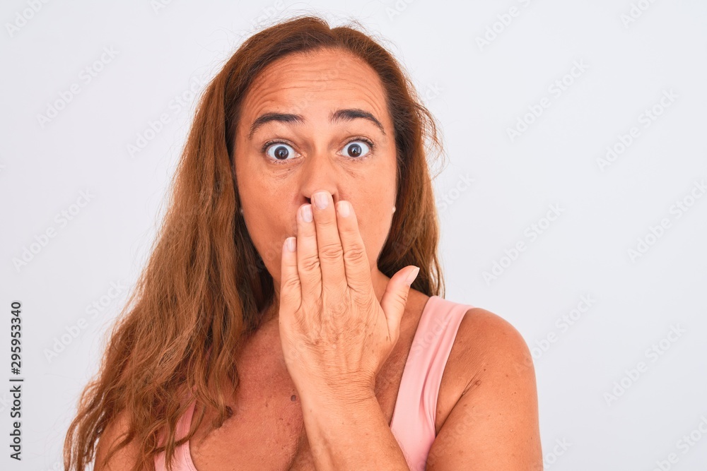 Middle age mature woman standing over white isolated background cover mouth with hand shocked with shame for mistake, expression of fear, scared in silence, secret concept Middle age mature woman standing over white isolated background cover mouth with hand shocked with shame for mistake, expression of fear, scared in silence, secret concept