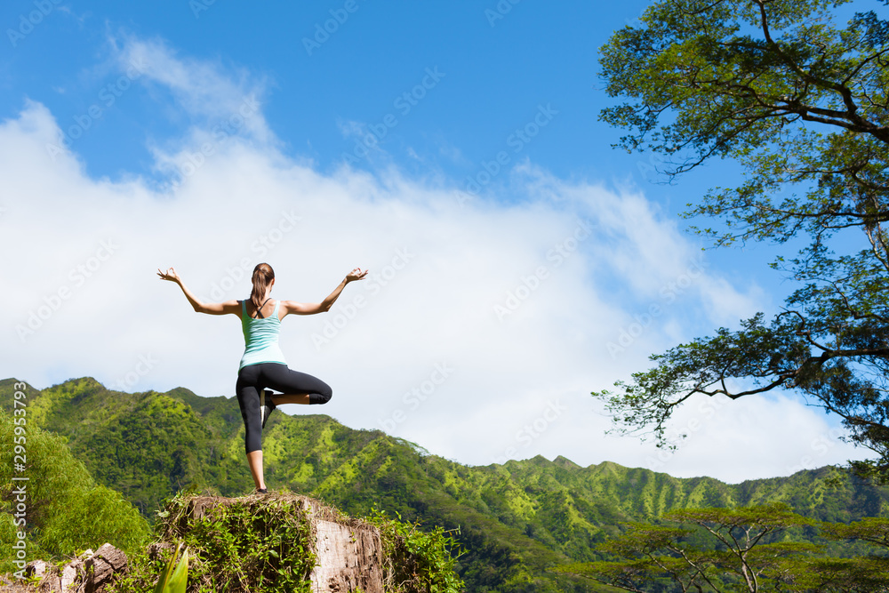Woman doing balancing yoga pose on a mountain Woman doing balancing yoga pose on a mountain