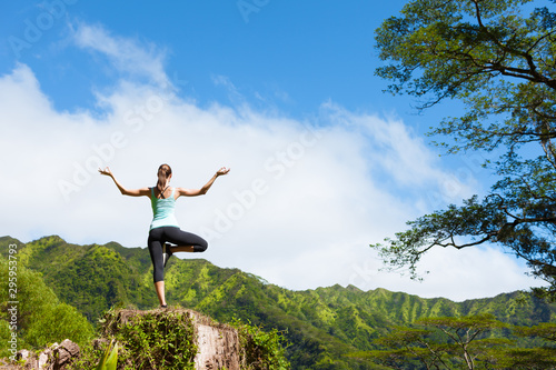 Woman doing balancing yoga pose on a mountain 