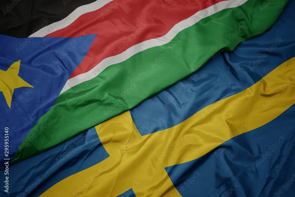waving colorful flag of sweden and national flag of south sudan. waving colorful flag of sweden and national flag of south sudan.