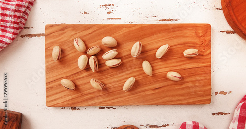 Pistachios on wooden board and white vintage background photo