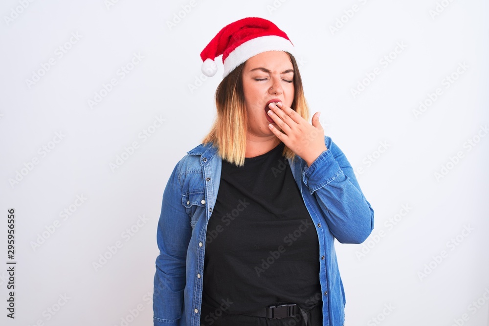 Young beautiful woman wearing Christmas Santa hat standing over isolated white background bored yawning tired covering mouth with hand. Restless and sleepiness. Young beautiful woman wearing Christmas Santa hat standing over isolated white background bored yawning tired covering mouth with hand. Restless and sleepiness.