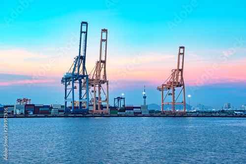 Containers cargo ship in harbour with working crane bridge in shipyard,transportation,logistics