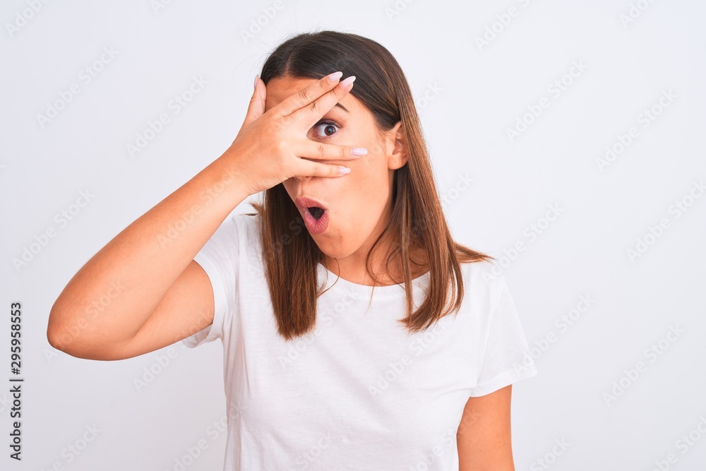 Portrait of beautiful and young brunette woman standing over isolated white background peeking in shock covering face and eyes with hand, looking through fingers with embarrassed expression. Portrait of beautiful and young brunette woman standing over isolated white background peeking in shock covering face and eyes with hand, looking through fingers with embarrassed expression.