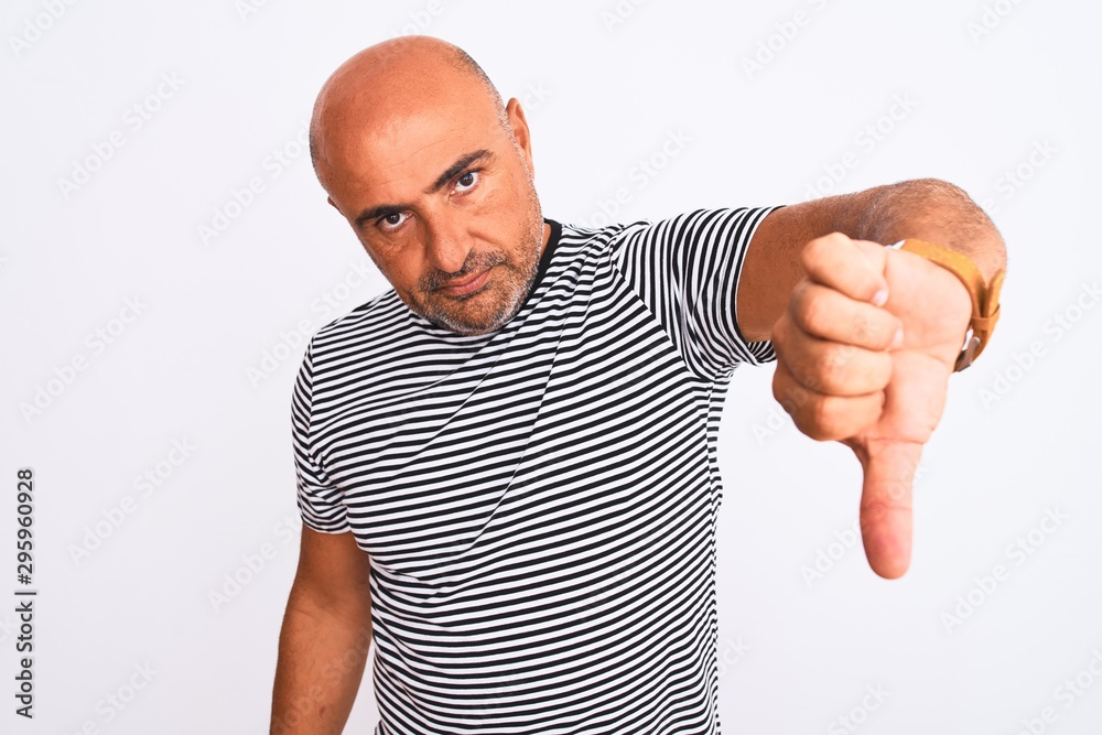 Middle age handsome man wearing striped navy t-shirt over isolated white background looking unhappy and angry showing rejection and negative with thumbs down gesture. Bad expression. Middle age handsome man wearing striped navy t-shirt over isolated white background looking unhappy and angry showing rejection and negative with thumbs down gesture. Bad expression.