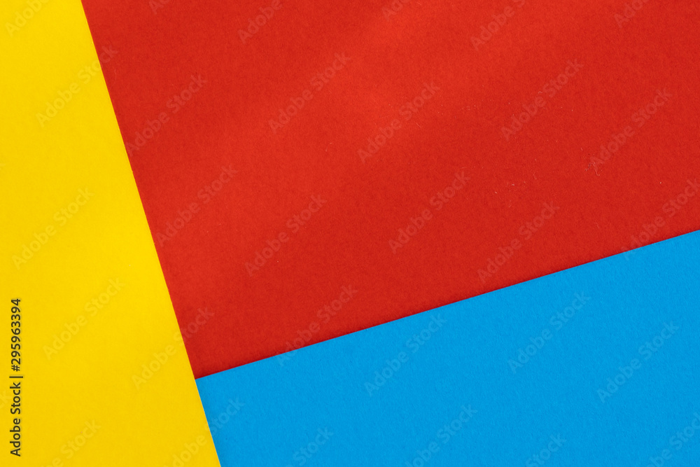 Yelllow blue red color paper background. Geometric figures, shapes. Abstract geometric flat composition. Empty space on monochrome cardboard. Yelllow blue red color paper background. Geometric figures, shapes. Abstract geometric flat composition. Empty space on monochrome cardboard.