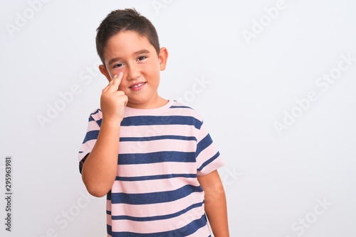 Beautiful kid boy wearing casual striped t-shirt standing over isolated white background winking looking at the camera with sexy expression, cheerful and happy face.