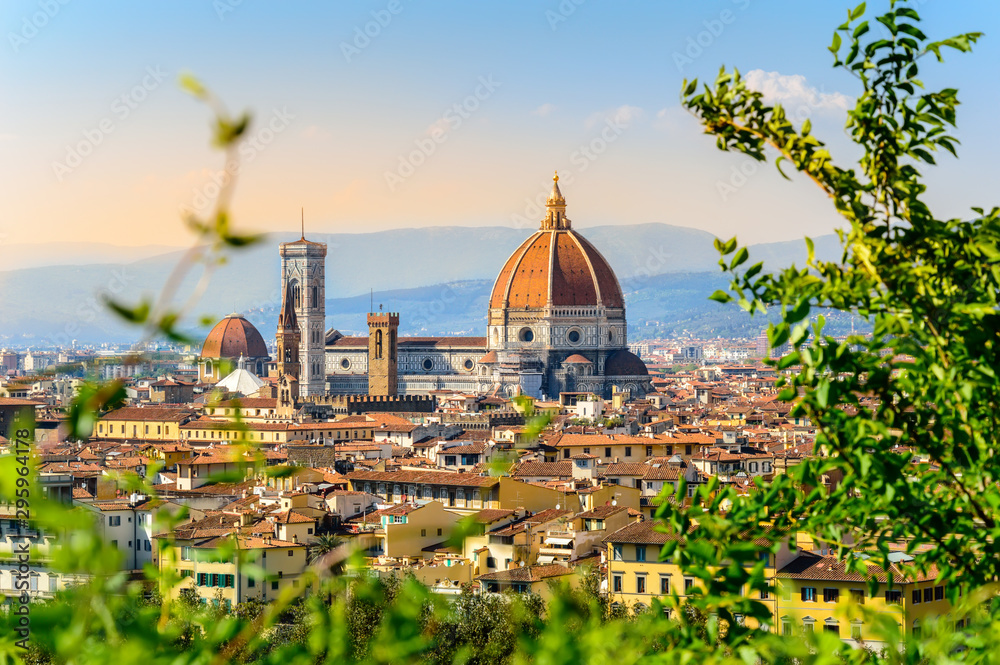 Florence, Italy: scenic view on famous italian town with Duomo at sunset with green leaves