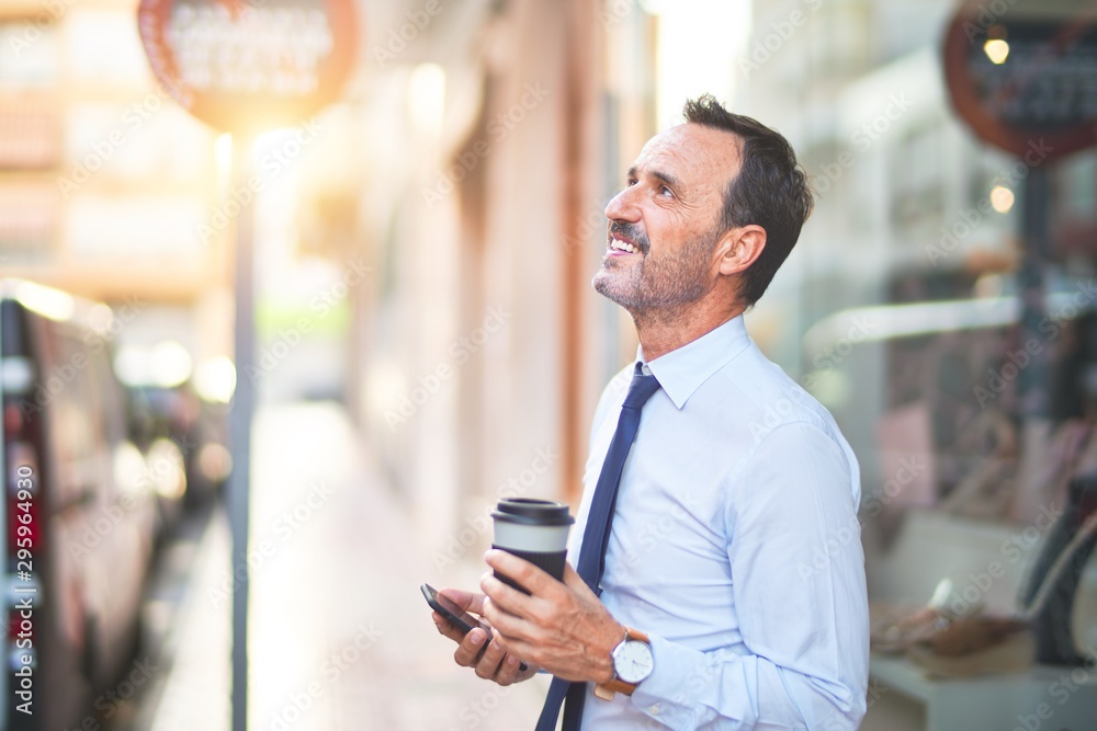 Middle age handsome businessman using smartphone drinking take away coffee smiling Middle age handsome businessman using smartphone drinking take away coffee smiling