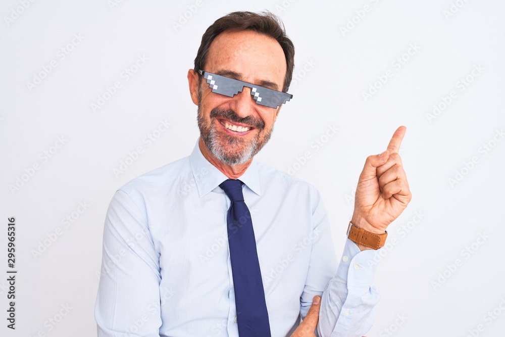Middle age businessman wearing thug life sunglasses over isolated white background with a big smile on face, pointing with hand and finger to the side looking at the camera. Middle age businessman wearing thug life sunglasses over isolated white background with a big smile on face, pointing with hand and finger to the side looking at the camera.