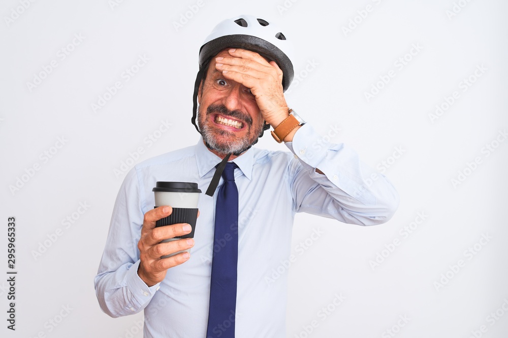 Middle age businessman wearing bike helmet drinking coffee over isolated white background stressed with hand on head, shocked with shame and surprise face, angry and frustrated. Fear and upset