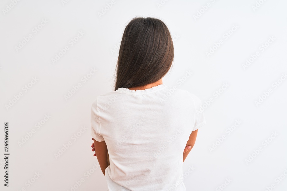 Young beautiful woman wearing casual t-shirt standing over isolated white background standing backwards looking away with crossed arms Young beautiful woman wearing casual t-shirt standing over isolated white background standing backwards looking away with crossed arms
