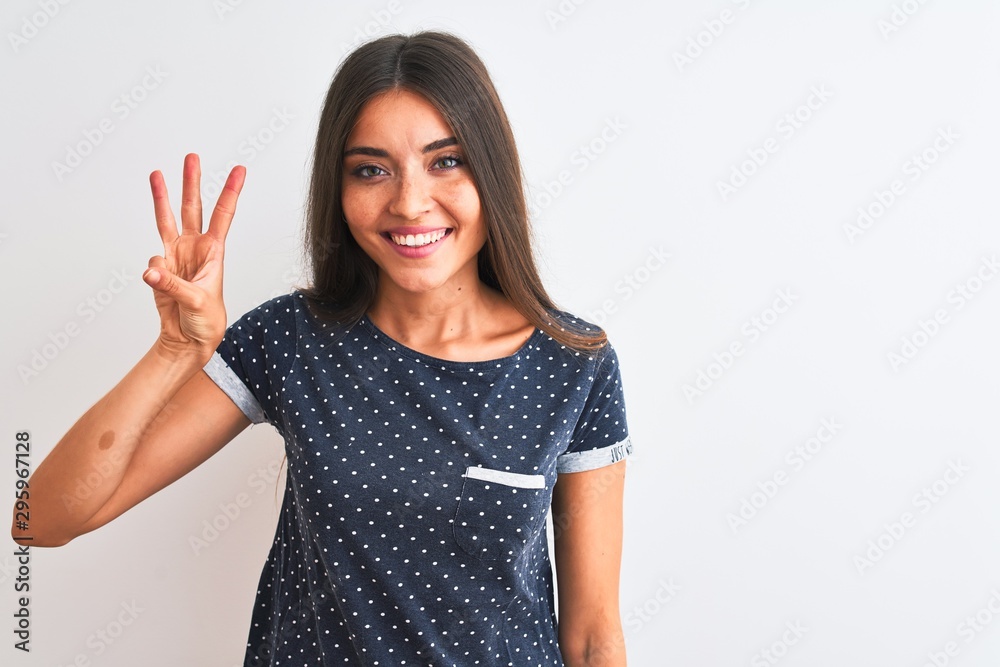 Young beautiful woman wearing blue casual t-shirt standing over isolated white background showing and pointing up with fingers number three while smiling confident and happy. Young beautiful woman wearing blue casual t-shirt standing over isolated white background showing and pointing up with fingers number three while smiling confident and happy.