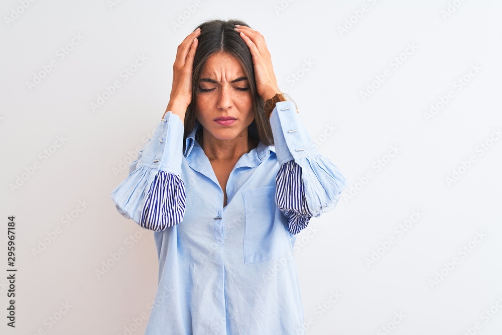 Young beautiful woman wearing blue elegant shirt standing over isolated white background suffering from headache desperate and stressed because pain and migraine. Hands on head. Young beautiful woman wearing blue elegant shirt standing over isolated white background suffering from headache desperate and stressed because pain and migraine. Hands on head.