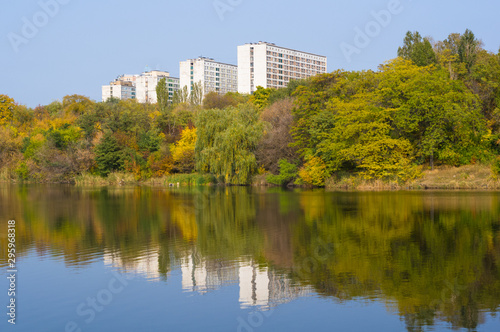 Autumn urban landscape on a Sunny day - yellow autumn trees in the Park  river  and bright sky with clouds