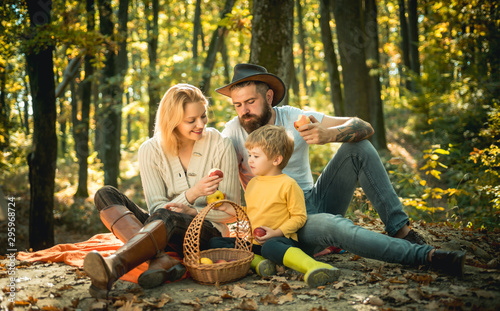 Picnic in nature. Country style family. Meaning of happy family. United with nature. Family day concept. Happy family with kid boy relaxing while hiking in forest. Mother father and small son picnic.