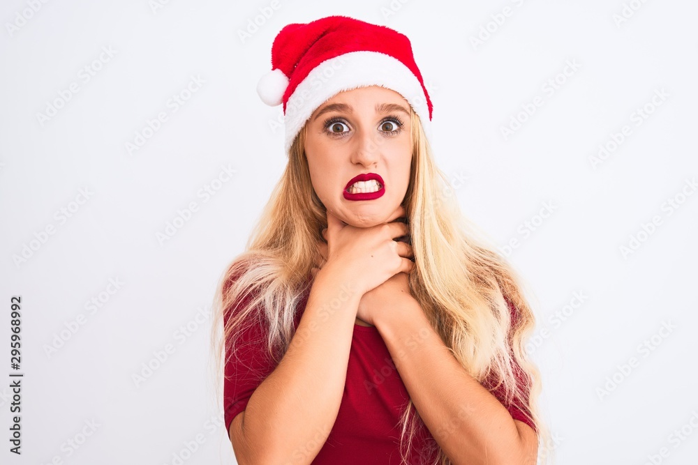 Young beautiful woman wearing Christmas Santa hat over isolated white background shouting and suffocate because painful strangle. Health problem. Asphyxiate and suicide concept. Young beautiful woman wearing Christmas Santa hat over isolated white background shouting and suffocate because painful strangle. Health problem. Asphyxiate and suicide concept.