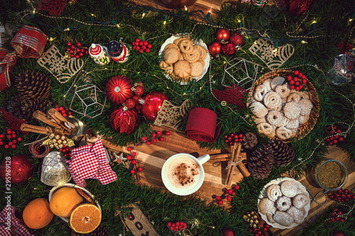 Obraz na płótnie Top View of a cup of Christmas hot chocolate on a table with holiday season ingredients like orange, cookies, panettone, cinnamon and pine w salonie