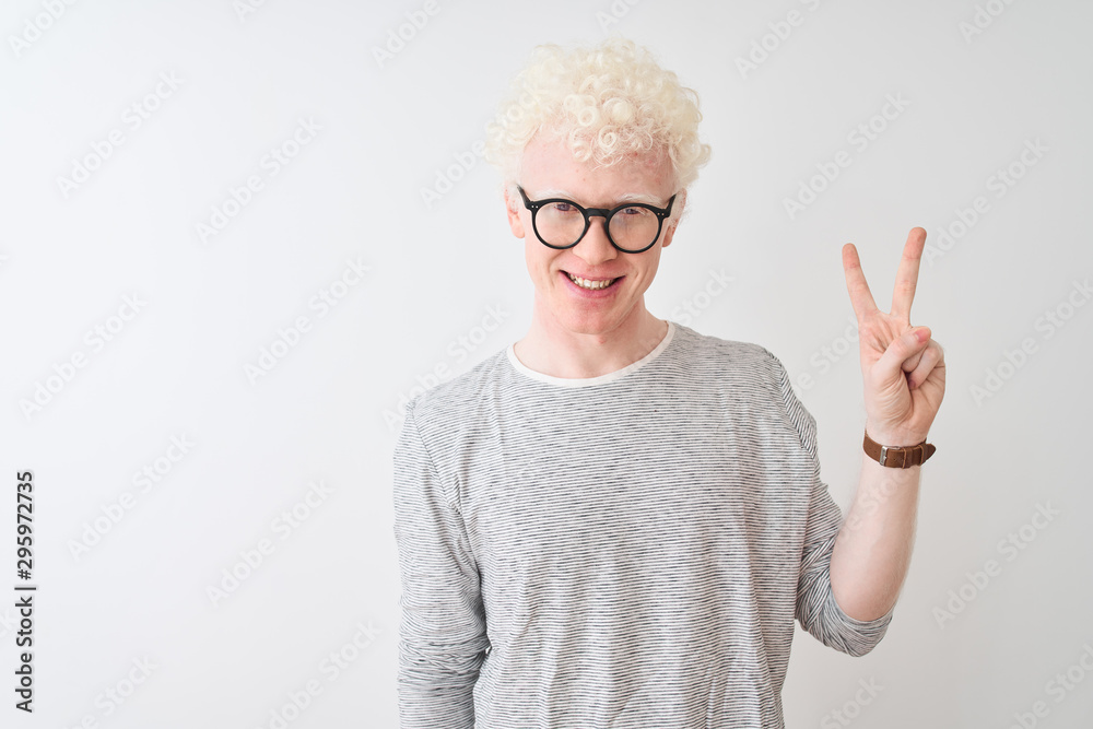 Young albino blond man wearing striped t-shirt and glasses over isolated white background showing and pointing up with fingers number two while smiling confident and happy. Young albino blond man wearing striped t-shirt and glasses over isolated white background showing and pointing up with fingers number two while smiling confident and happy.