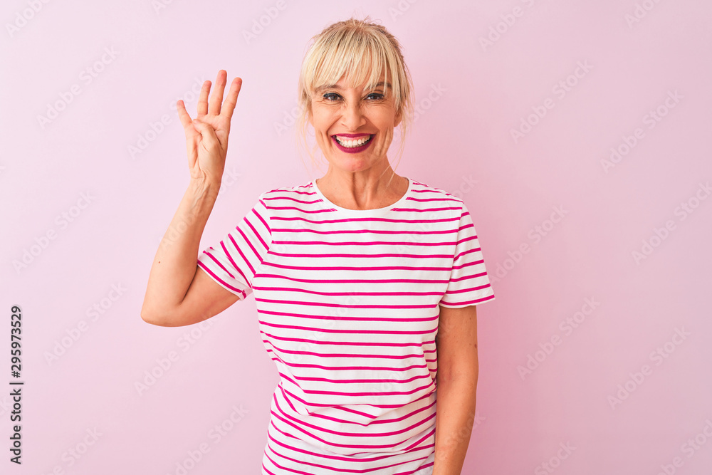 Middle age woman wearing striped t-shirt standing over isolated pink background showing and pointing up with fingers number four while smiling confident and happy. Middle age woman wearing striped t-shirt standing over isolated pink background showing and pointing up with fingers number four while smiling confident and happy.