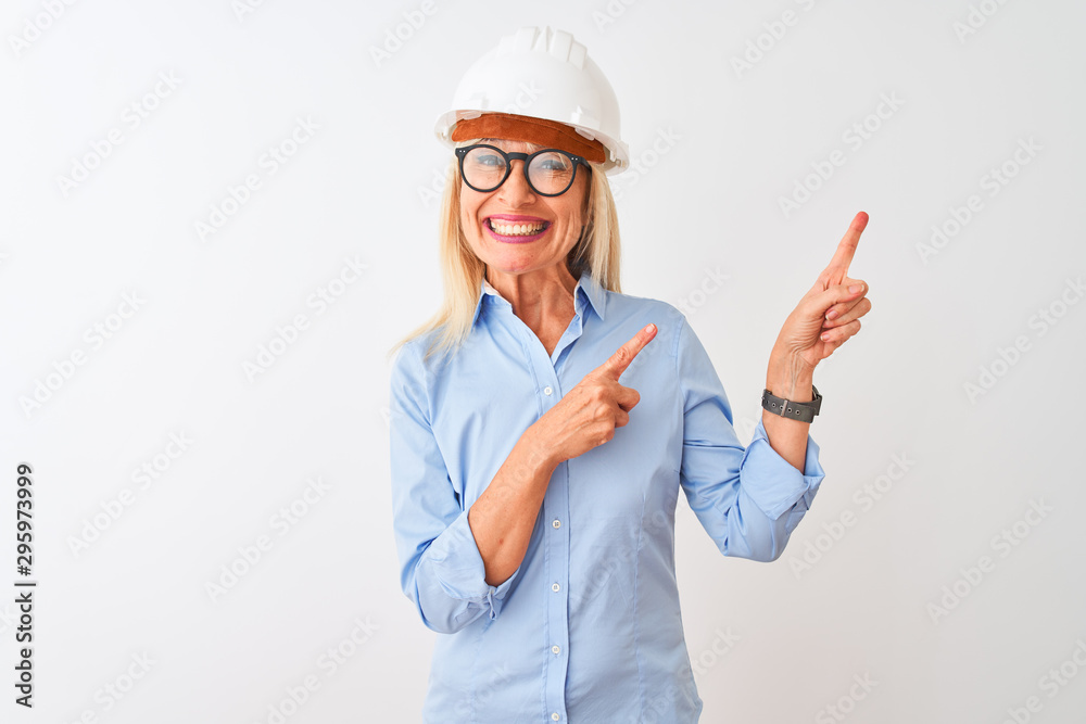 Middle age architect woman wearing glasses and helmet over isolated white background smiling and looking at the camera pointing with two hands and fingers to the side. Middle age architect woman wearing glasses and helmet over isolated white background smiling and looking at the camera pointing with two hands and fingers to the side.