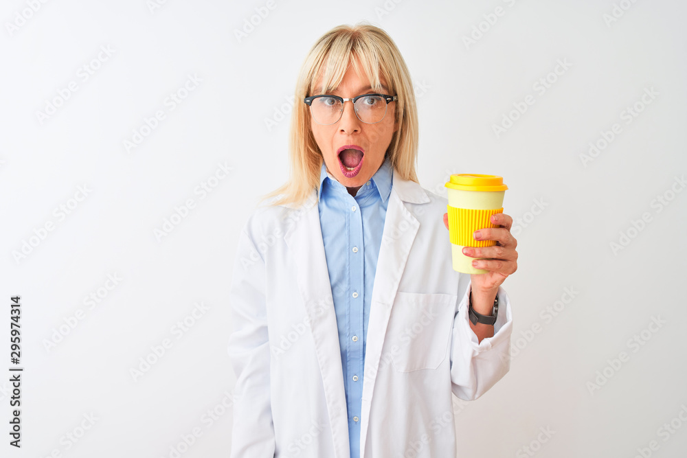 Middle age scientist woman wearing glasses drinking coffee over isolated white background scared in shock with a surprise face, afraid and excited with fear expression Middle age scientist woman wearing glasses drinking coffee over isolated white background scared in shock with a surprise face, afraid and excited with fear expression