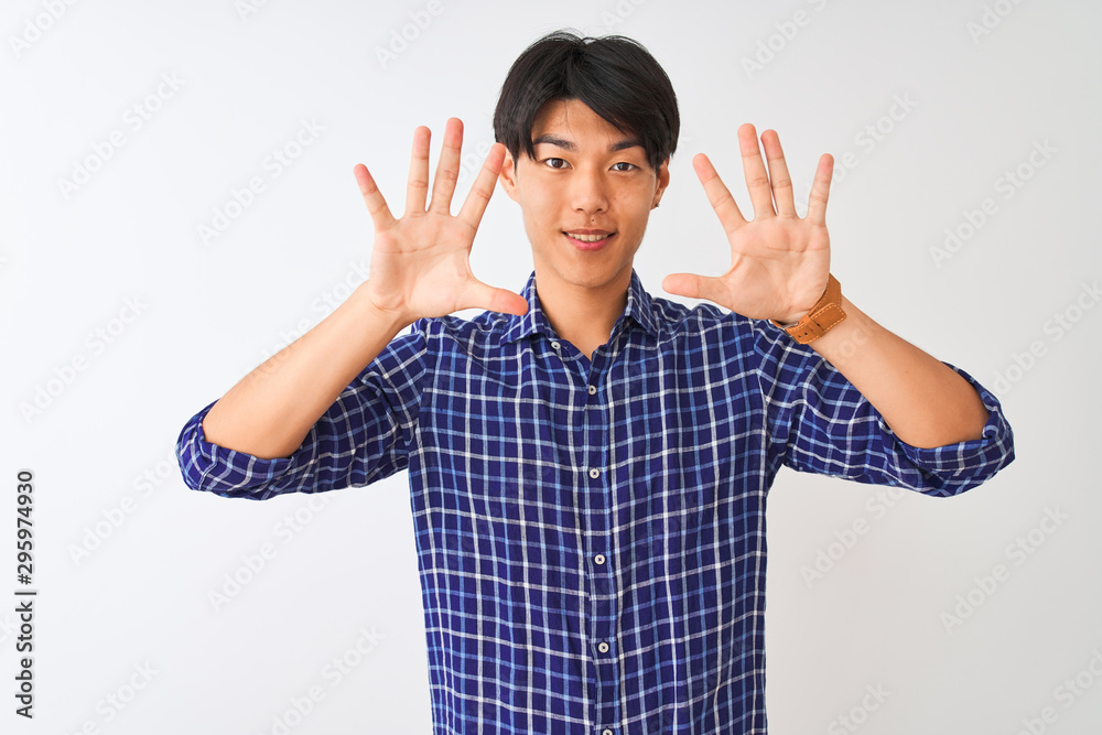 Young chinese man wearing casual blue shirt standing over isolated white background showing and pointing up with fingers number ten while smiling confident and happy. Young chinese man wearing casual blue shirt standing over isolated white background showing and pointing up with fingers number ten while smiling confident and happy.