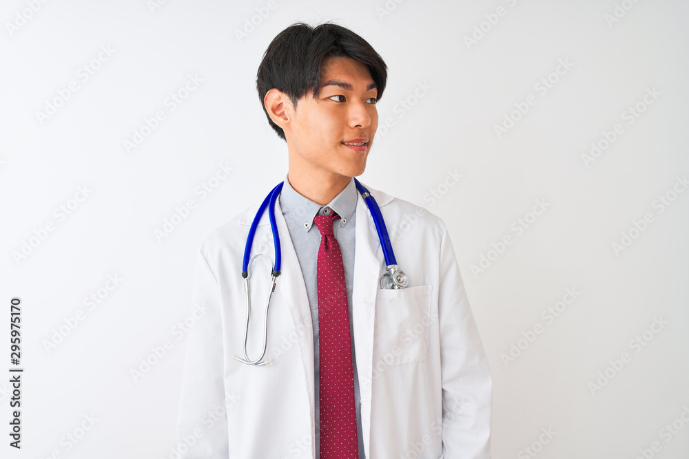 Chinese doctor man wearing coat tie and stethoscope over isolated white background looking away to side with smile on face, natural expression. Laughing confident. Chinese doctor man wearing coat tie and stethoscope over isolated white background looking away to side with smile on face, natural expression. Laughing confident.