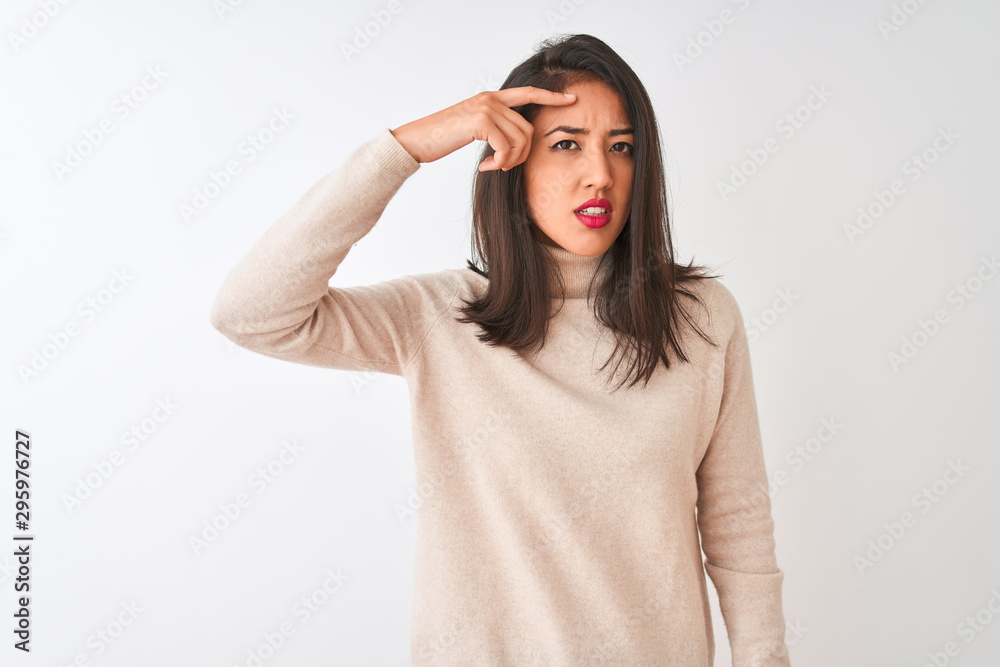 Beautiful chinese woman wearing turtleneck sweater standing over isolated white background pointing unhappy to pimple on forehead, ugly infection of blackhead. Acne and skin problem Beautiful chinese woman wearing turtleneck sweater standing over isolated white background pointing unhappy to pimple on forehead, ugly infection of blackhead. Acne and skin problem