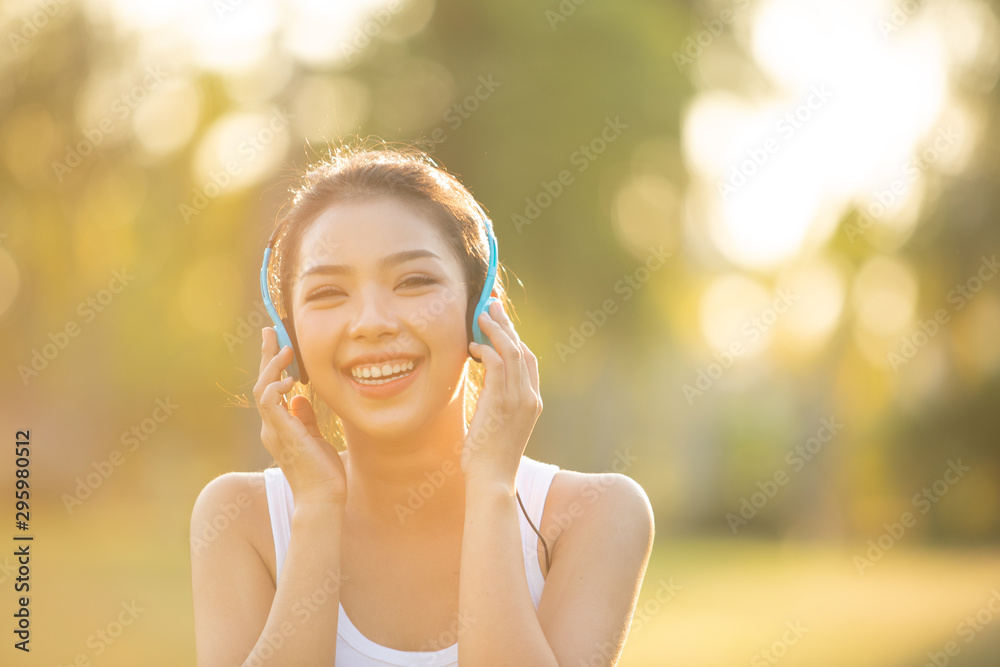 Beautiful Young Woman with Headphones Outdoors. Enjoying Music - obrazy, fototapety, plakaty 