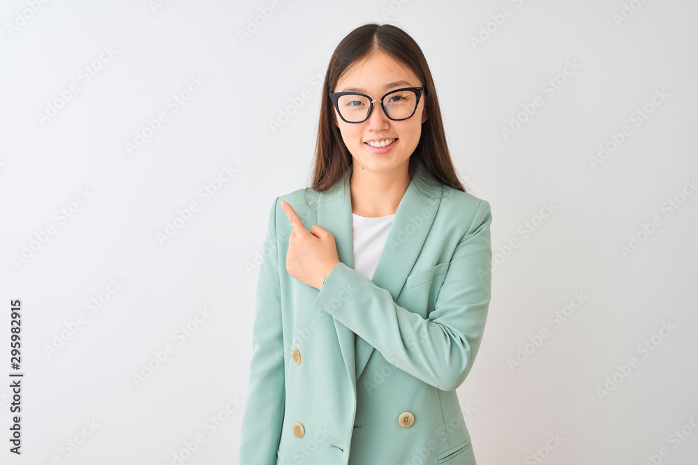 Chinese businesswoman wearing elegant jacket and glasses over isolated white background cheerful with a smile of face pointing with hand and finger up to the side with happy and natural expression Chinese businesswoman wearing elegant jacket and glasses over isolated white background cheerful with a smile of face pointing with hand and finger up to the side with happy and natural expression