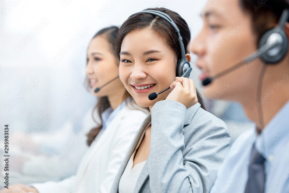 Smiling beautiful Asian woman working in call center office Smiling beautiful Asian woman working in call center office