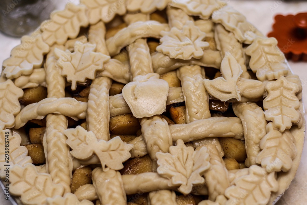 Selective Focus Closeup of a decorative unbaked pie crust with braids and autumn leaves Selective Focus Closeup of a decorative unbaked pie crust with braids and autumn leaves