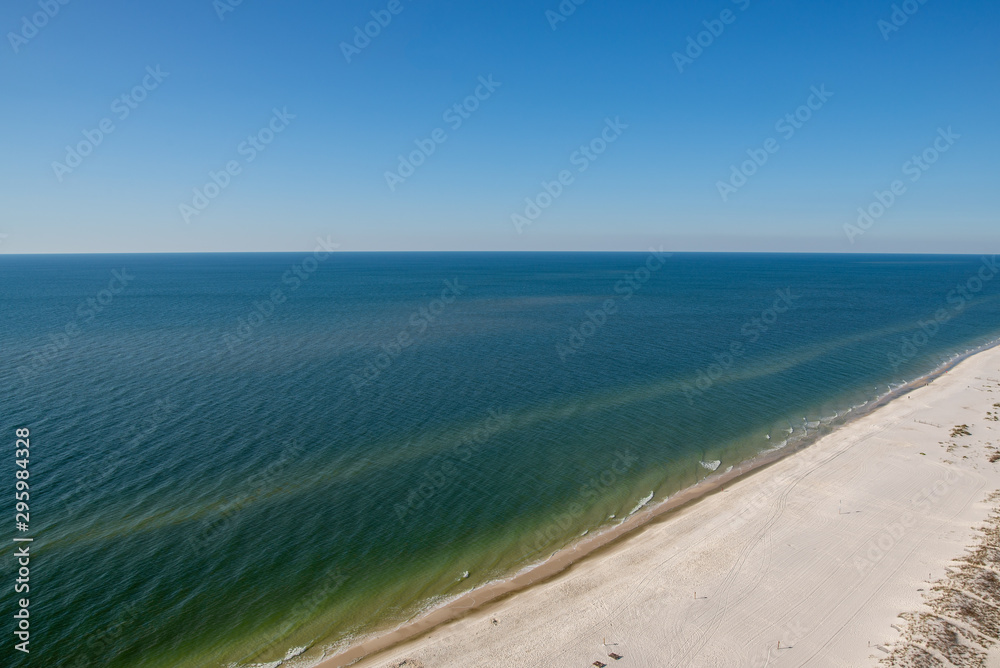 Aerial shot over beach and sandbar on a western horizon