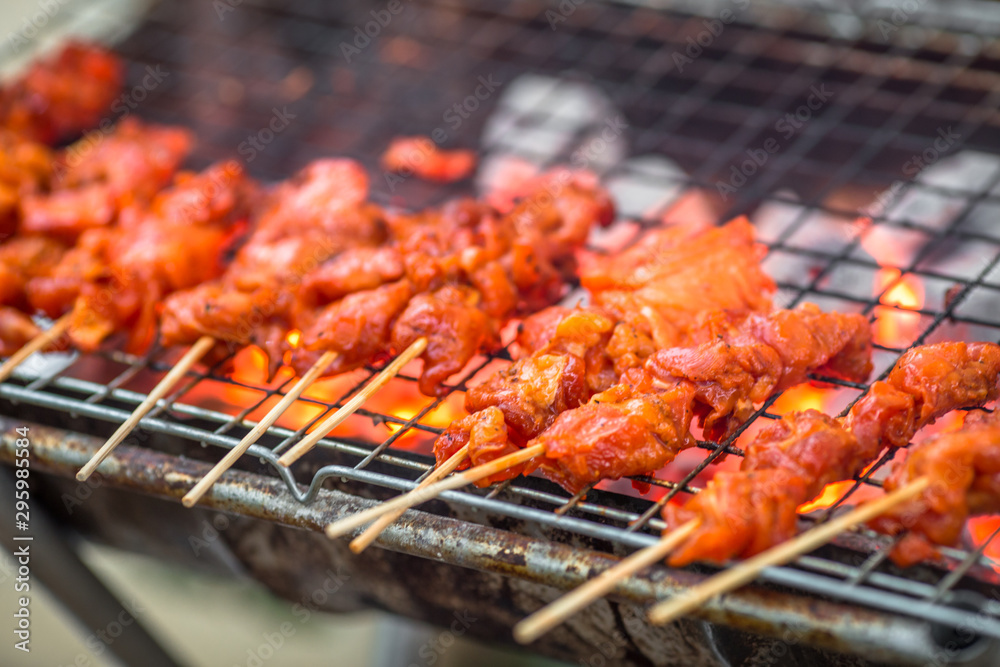 The blurred background of grilling chicken on a charcoal grill, with the heat of the flame from the oil of the meat, spreading smoke and a fragrant flavor from the food smell.