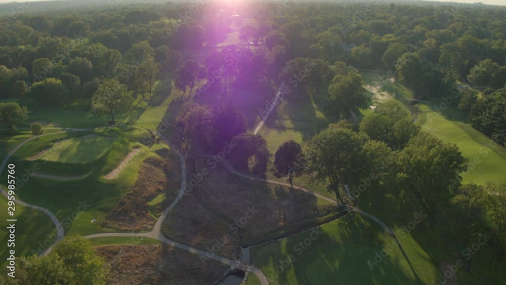 Aerial pull away over a beautiful golf course at sunset Aerial pull away over a beautiful golf course at sunset