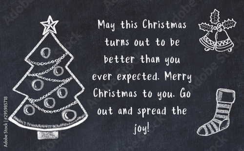 Drawing of christmas tree and handwritten greetings on black chalkboard  photo